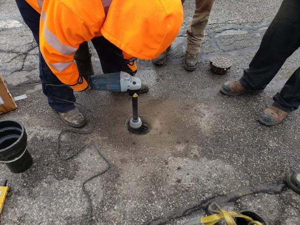 Photo of men using a kerf cutter from HydroVerge to complete a street valve box repair